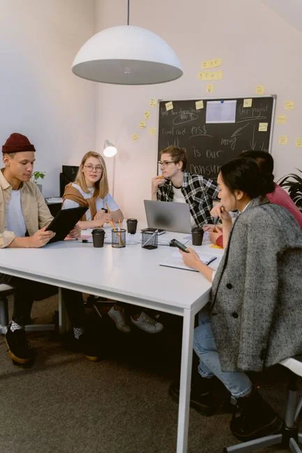 A team examining financial charts and digital data on tablets in an office environment.